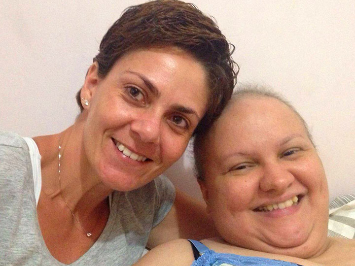 Um paciente tratando câncer e uma familiar sorriem