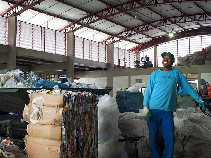 Foto do Instituto S.O.S. - Um homem trabalhador sorri em um centro de reciclagem
